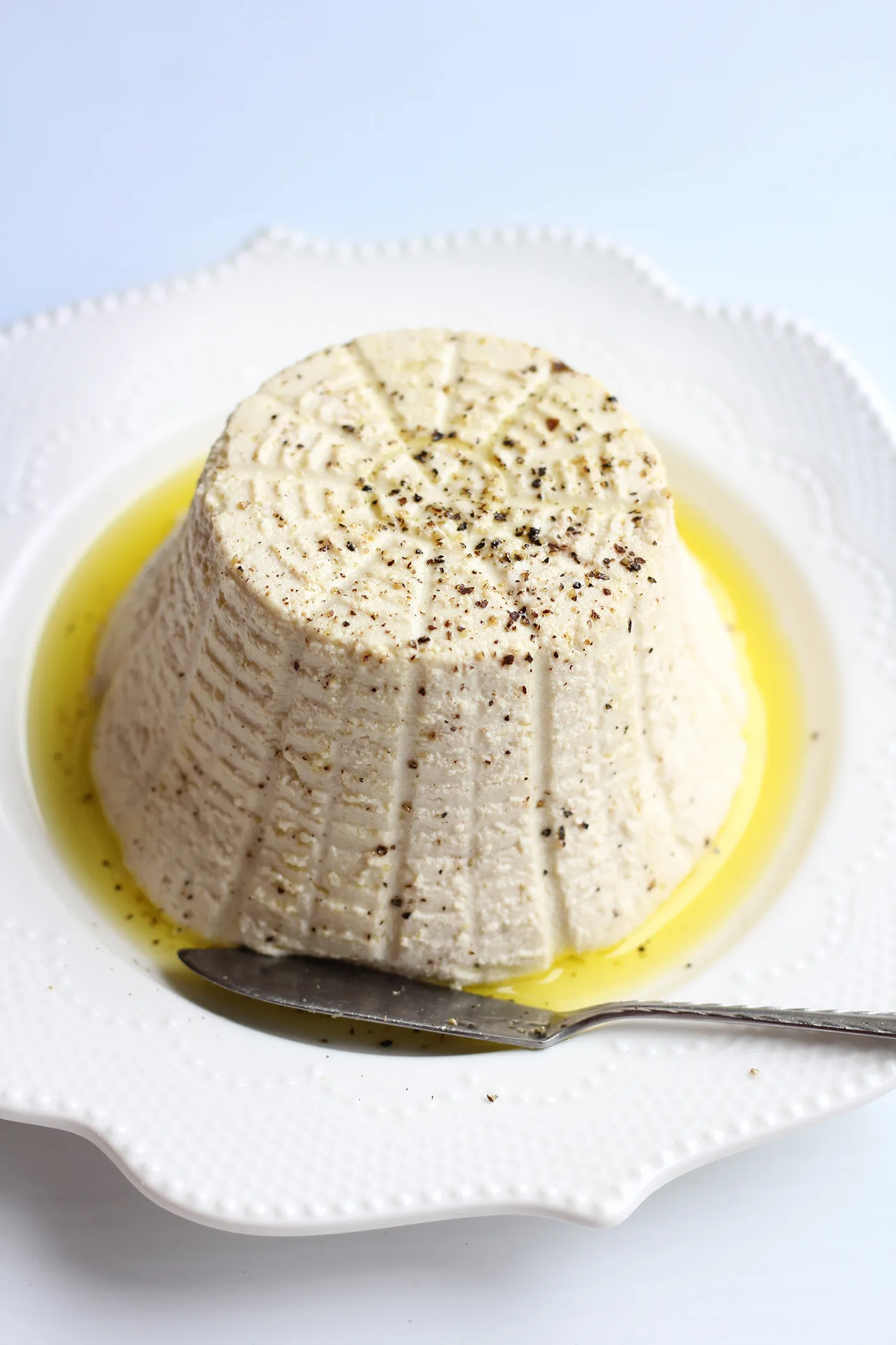 Tofu ricotta in a ricotta mould, drizzled with olive oil